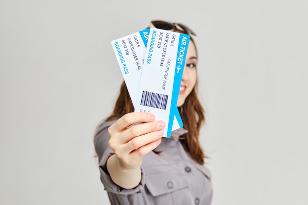 Foto mädchen hält vorwärtsflugtickets mit einem lächeln.