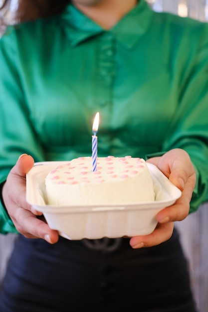 Mädchen halten Bento-Kuchen dekoriert mit roten Herzen Kuchen für eine Person eine Kerze in der Mitte des Kuchens