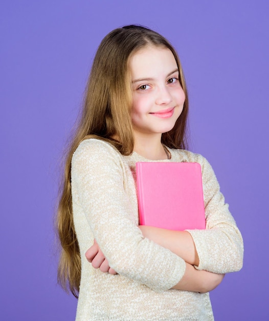 Mädchen halten Buch violetten Hintergrund Kid Show Buch Buchkonzept Weise Zitate Kindheitsliteratur Entwicklung und Bildung Lesefähigkeit Persönliches Tagebuch Lehrbuchpräsentation Studieren und lernen