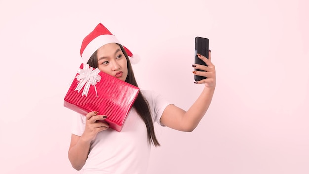 Mädchen halten Geschenkbox machen Selfie oder Video online mit weihnachtlichem Requisitenzubehör