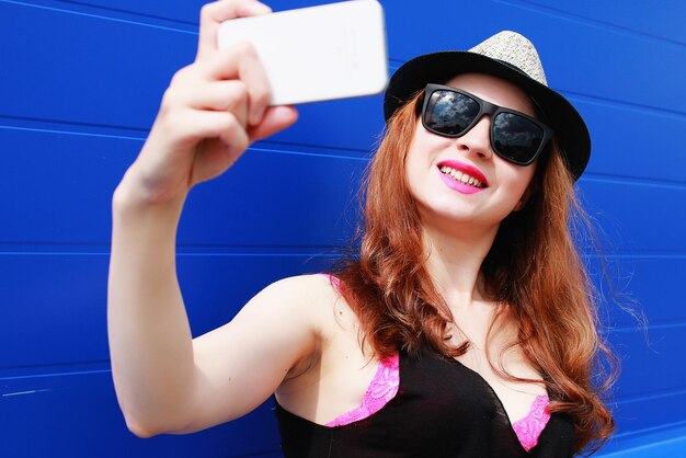 Mädchen-Hipster in einem leichten Hut und einer Sonnenbrille an einem Sommertag