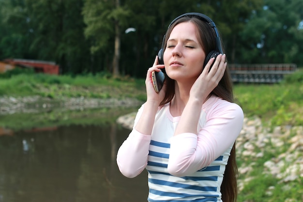 Mädchen hören Musik im Kopfhörer im Freien