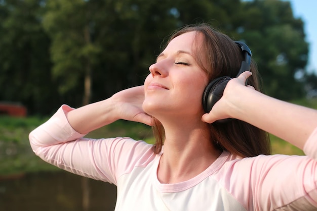 Mädchen hören Musik im Kopfhörer im Freien