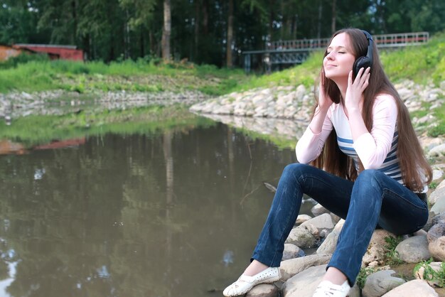 Mädchen hören Musik im Kopfhörer im Freien