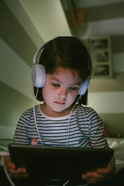 Mädchen hört Musik, während sie zu Hause ein digitales Tablet benutzt