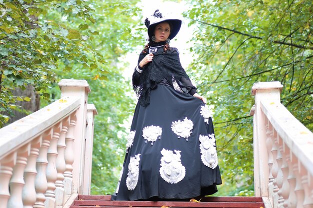 Mädchen im alten Retro-Kleid auf der Treppe im Freien