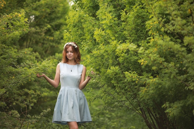 Mädchen im blauen Kleid im grünen Park