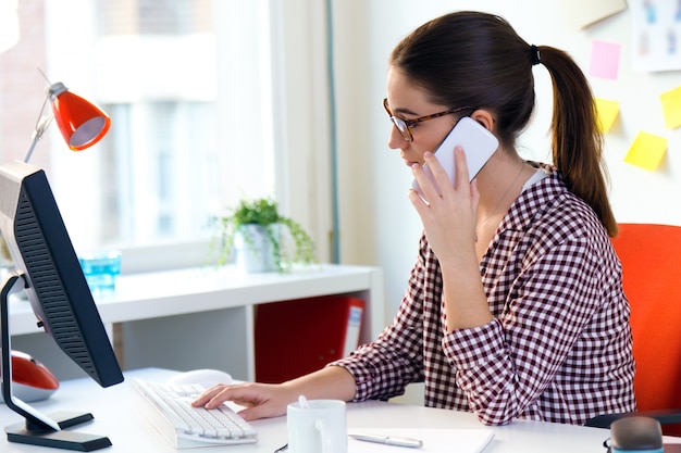 Mädchen im Büro jemanden am Telefon anrufen