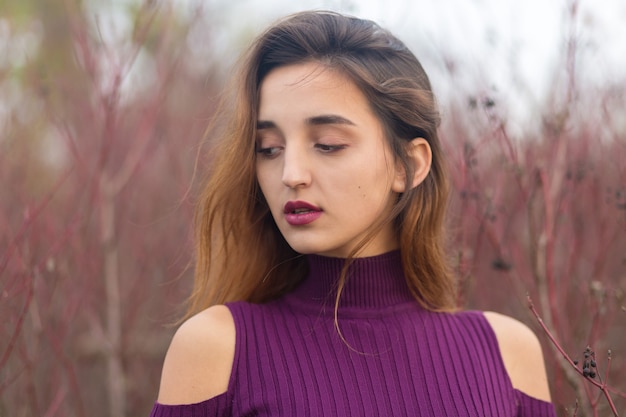 Mädchen im lila Kleid auf Natur im Herbst, Porträt eines schönen Mädchens im Herbst im Wald