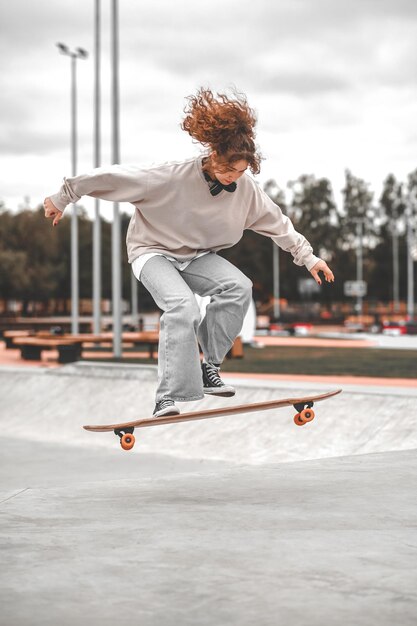 Mädchen im Moment des Springens über das Skateboard