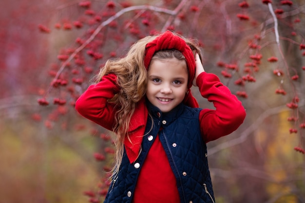 Mädchen im roten Outfit im Herbstwald