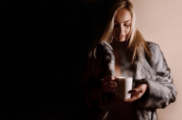 Mädchen im warmen Kleid mit Kaffeetasse