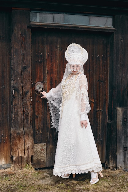 Mädchen im weißen ethnischen russischen Kleid