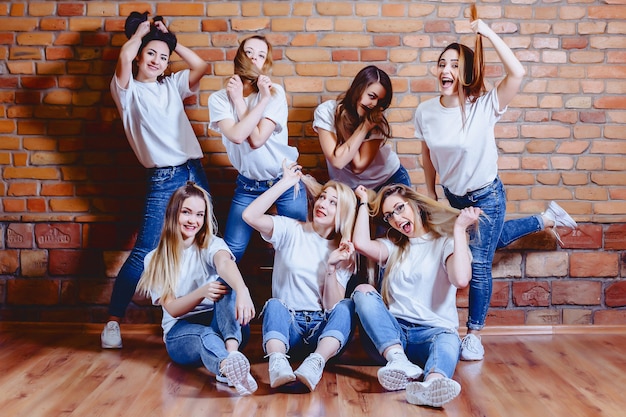 Mädchen in den Jeans am Hintergrund der Backsteinmauer