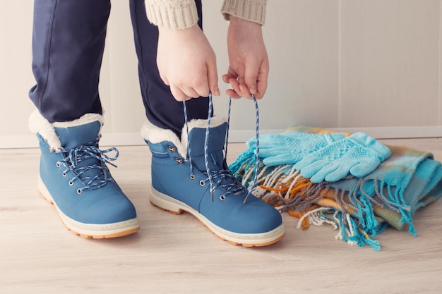 Foto mädchen in den winterschuhen auf dem boden