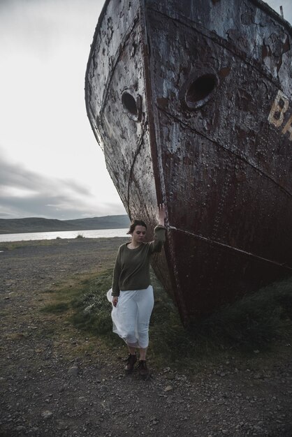 Foto mädchen in der nähe des riesigen schiffes in island