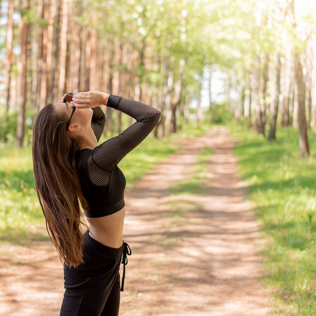 Mädchen in der Uniform und Sonnenbrille, die Sport in einem Park tut