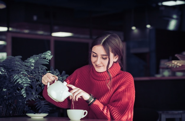 Mädchen in einem Café, das Tee dient