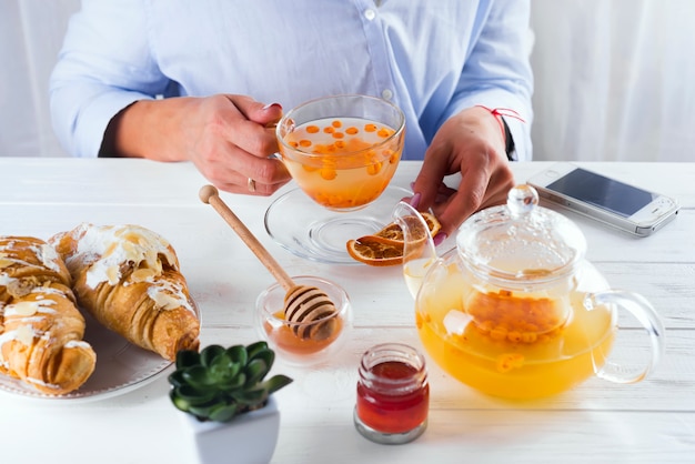 Mädchen in einem Café trinkt Sanddorntee