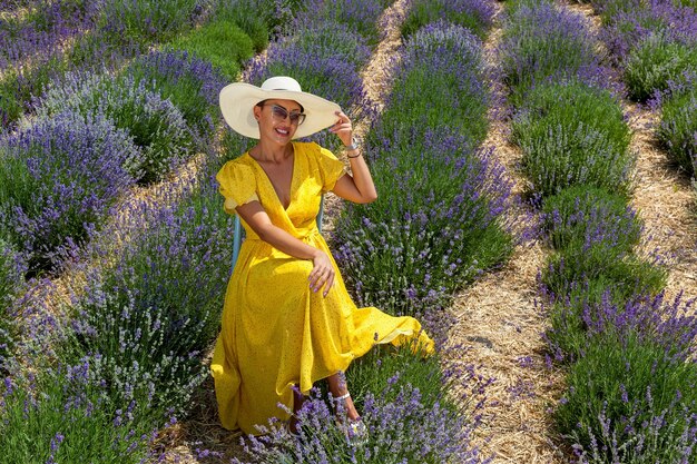 Mädchen in einem gelben Kleid in einem Lavendelfeld