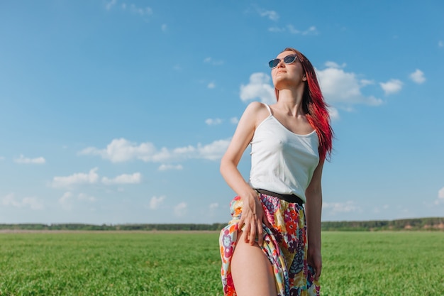 Mädchen in einem grünen Feld, das den Sonnenkopierraum betrachtet