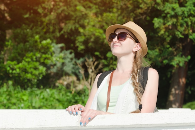 Mädchen in einem Hut mit Sonnenbrille Natur genießend. Sonniger Tag, Park