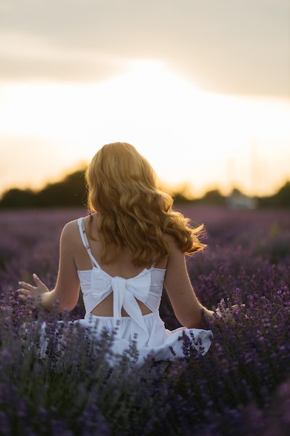 Mädchen in einem Lavendelfeld Frau in einem Feld von Lavendelblüten bei Sonnenuntergang in einem weißen Kleid Frankreich Provence