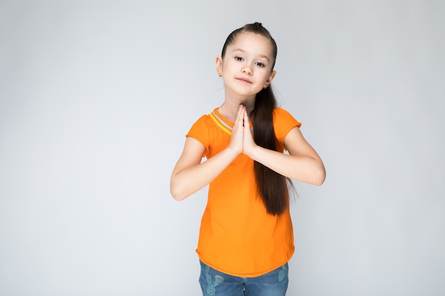 Mädchen in einem orangefarbenen T-Shirt und Blue Jeans