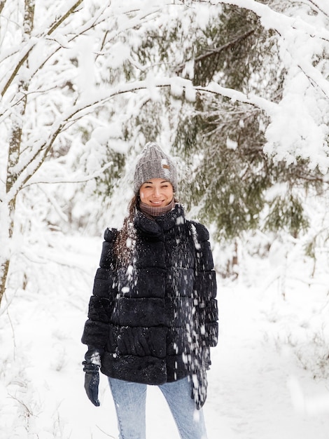 Mädchen in einem Pelzmantel in einem verschneiten Wald