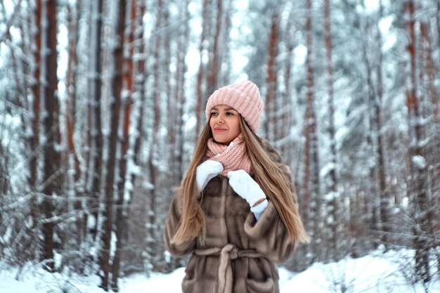 Mädchen in einem Pelzmantel in einem Winterpark