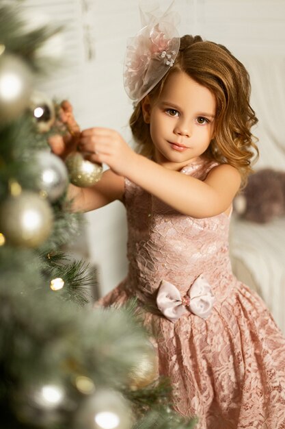 Mädchen in einem Raum mit Weihnachtsbaum und Dekorationen