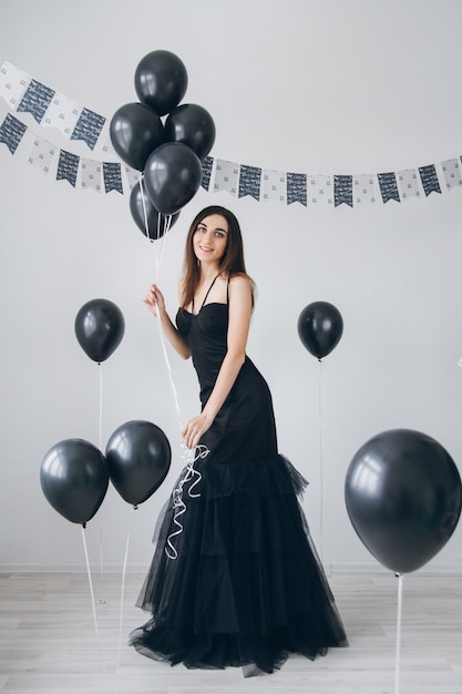 Mädchen in einem schwarzen Kleid mit schwarzen Ballonen