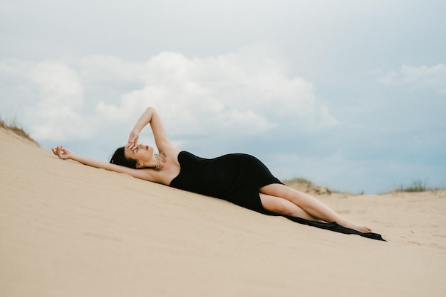 Mädchen in einem schwarzen langen Kleid in einer Sandwüste