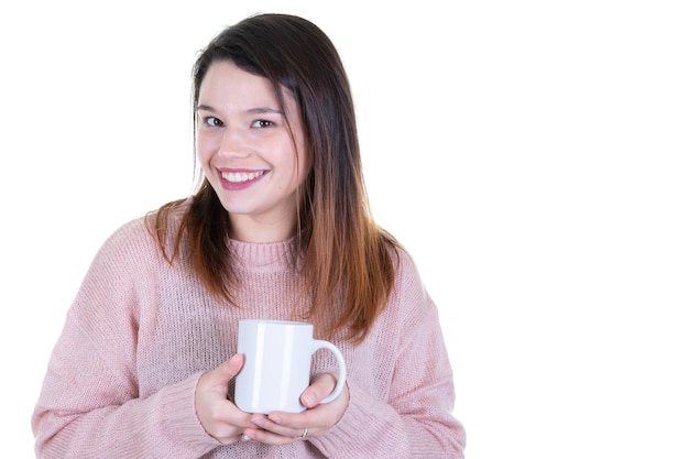 Mädchen in einem warmen rosa Pullover hält weißen Becher in den Händen