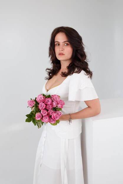 Mädchen in einem weißen Kleid mit einem Blumenstrauß