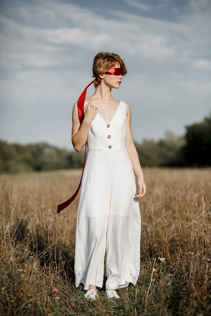 Mädchen in einem weißen Kleid mit einem roten Band
