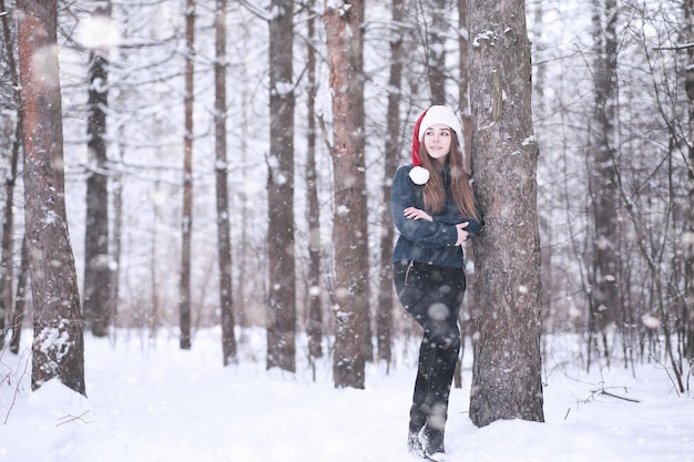 Mädchen in einem Winterpark im Schneefall