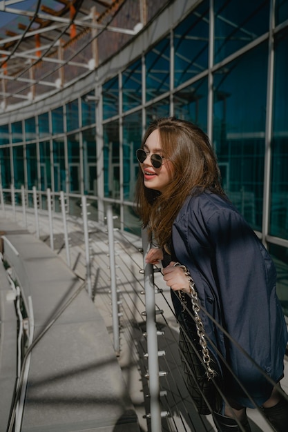 Mädchen in einer Jacke lacht auf dem Balkon