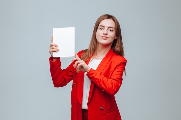 Mädchen in einer roten Jacke hält ein leeres Notizbuch