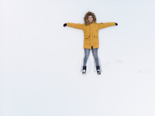 Mädchen in Gelb auf dem Schnee - Draufsicht