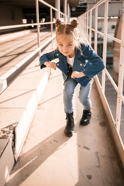 Mädchen in Jeanskleidung tanzt Hip-Hop auf dem Parkplatz