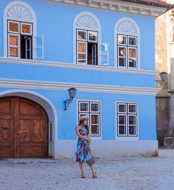 Mädchen in Kleid und Hut geht um Brasov herum