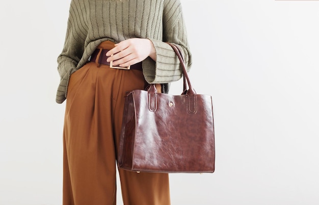 Mädchen in moderner Kleidung mit Handtasche auf weißem Hintergrund