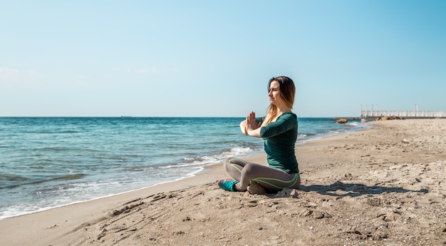 Mädchen in Sportbekleidung Fitness am Meer zuhören