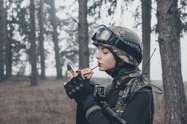 Mädchen in Tarnung mit einer Waffe