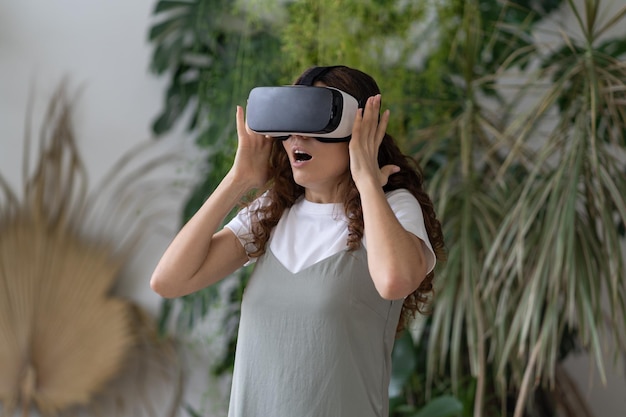 Mädchen in Vr-Brille lächeln nach der Arbeit mit Virtual-Reality-Brille interagieren, um sich im heimischen Garten zu entspannen