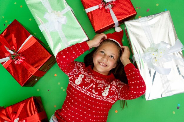 Mädchen in Weihnachtsmütze mit Geschenkboxen