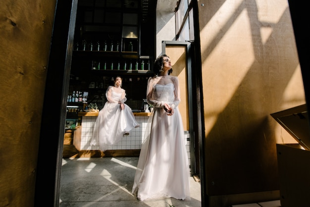 Mädchen in weißen Hochzeitskleidern werfen auf.