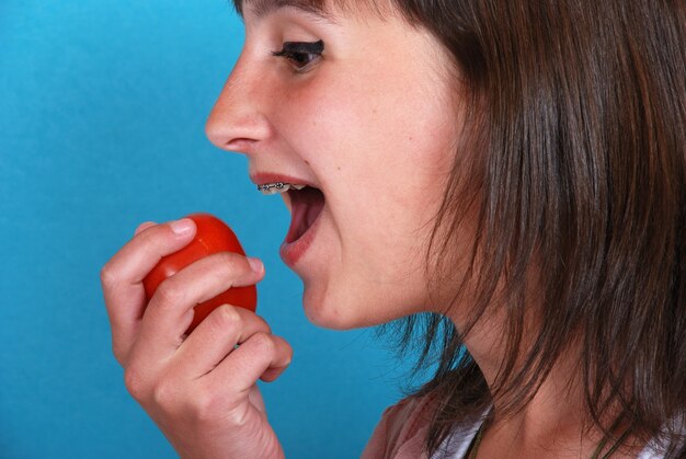 Mädchen isst eine Tomate