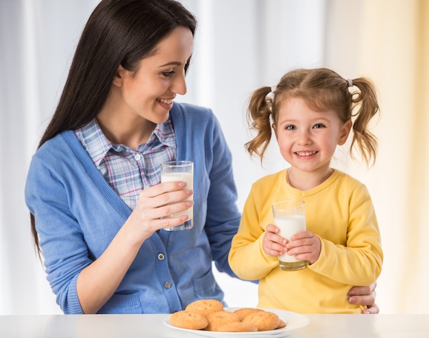 Mädchen isst einen gesunden Snack mit Keksen und Milch.